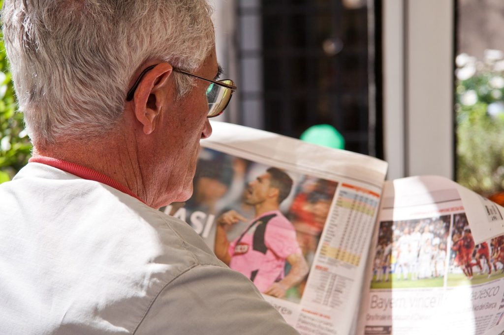 man reading newspaper in kansas