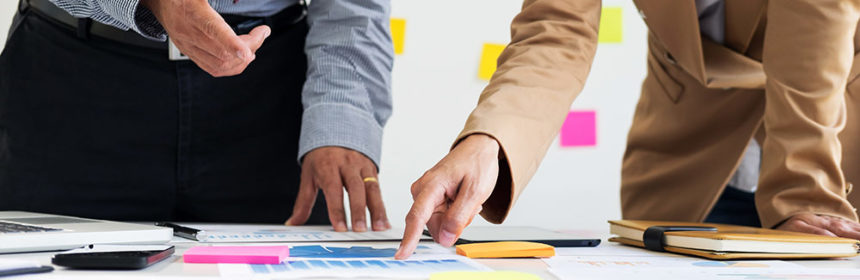 Business man and woman looking at papers on table in front of them