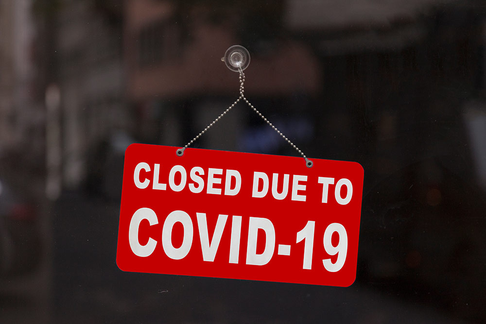 Red sign on door reads closed due to covid 19